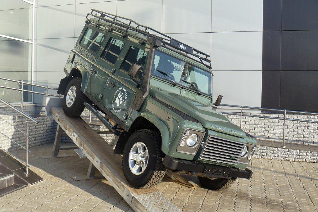 Defender 2579. Лэнд Ровер Дефендер зеленый 2021 с лестницей ю. Дефендер 110 или ТЛК 76. Силовой бампер диски на ленд Ровер Дефендер 110. Defender автосалон.